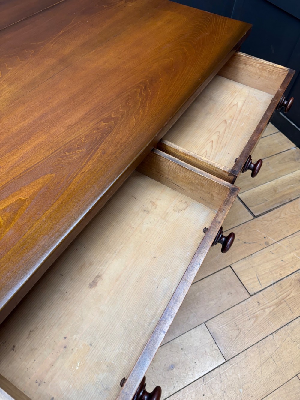 A Victorian mahogany writing table featuring two front drawers with wooden turned knobs, four turned legs, and a drop-leaf panel. View VI