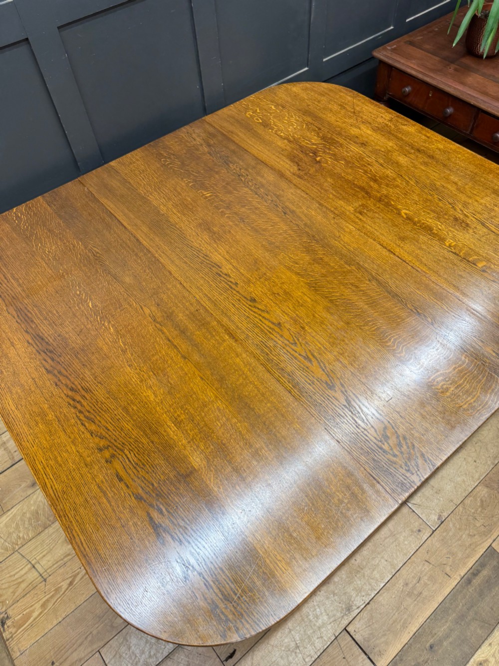 An Edwardian solid oak gateleg dining table with fully extended drop leaves, turned baluster legs, and lower stretchers. View III
