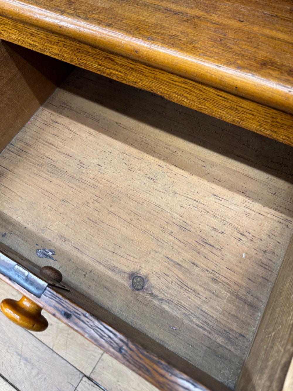 An antique oak chest of drawers featuring two short drawers above three long graduating drawers, complete with turned wooden knobs and bracket feet. View VI