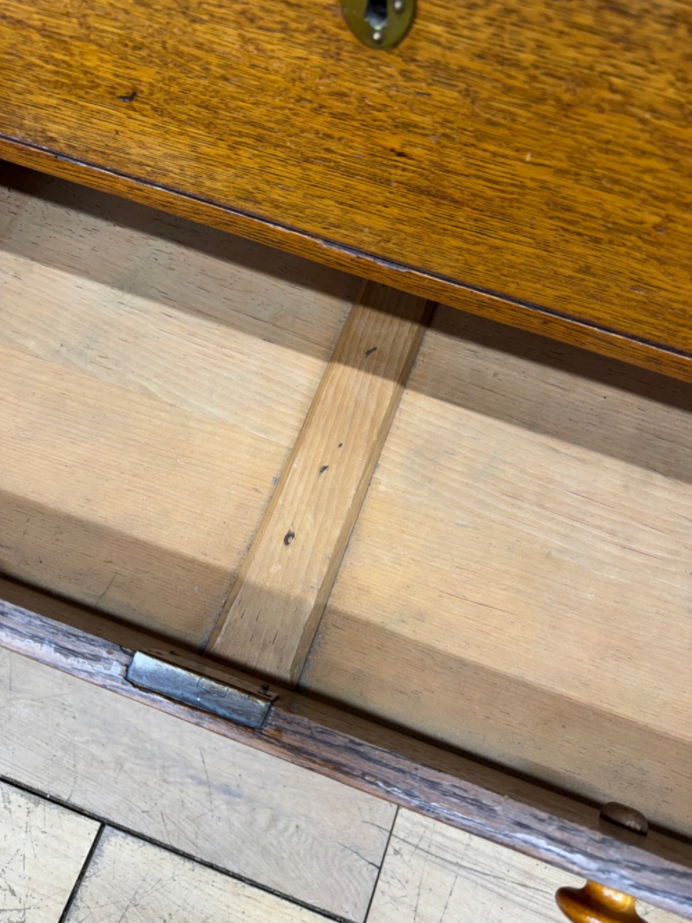 An antique oak chest of drawers featuring two short drawers above three long graduating drawers, complete with turned wooden knobs and bracket feet. View VII