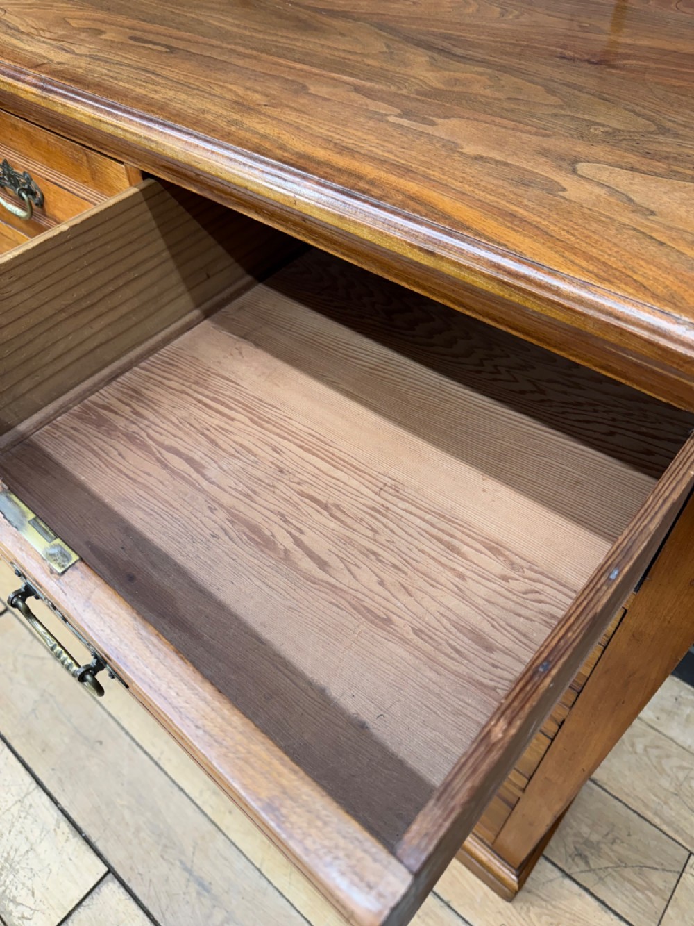 A Victorian antique walnut chest featuring two short over three long drawers with ornate brass handles and reeded drawer fronts resting on a solid plinth base. View IV
