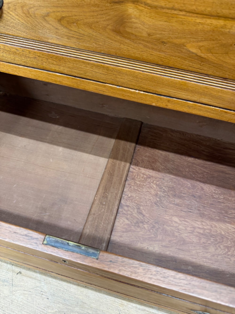 A Victorian antique walnut chest featuring two short over three long drawers with ornate brass handles and reeded drawer fronts resting on a solid plinth base. View VI
