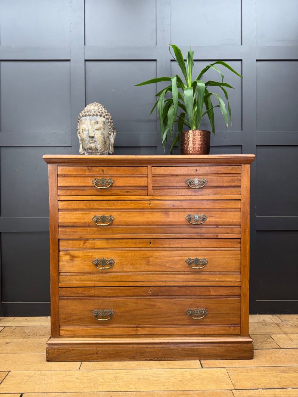 A Victorian antique walnut chest featuring two short over three long drawers with ornate brass handles and reeded drawer fronts resting on a solid plinth base. View VII