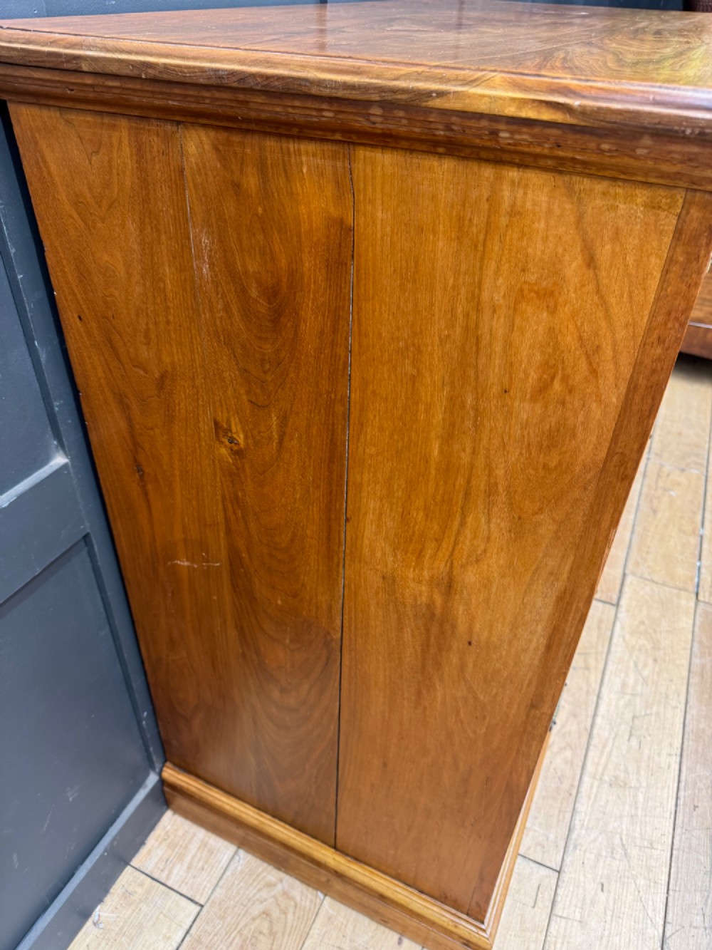 A Victorian antique walnut chest featuring two short over three long drawers with ornate brass handles and reeded drawer fronts resting on a solid plinth base. View VIII