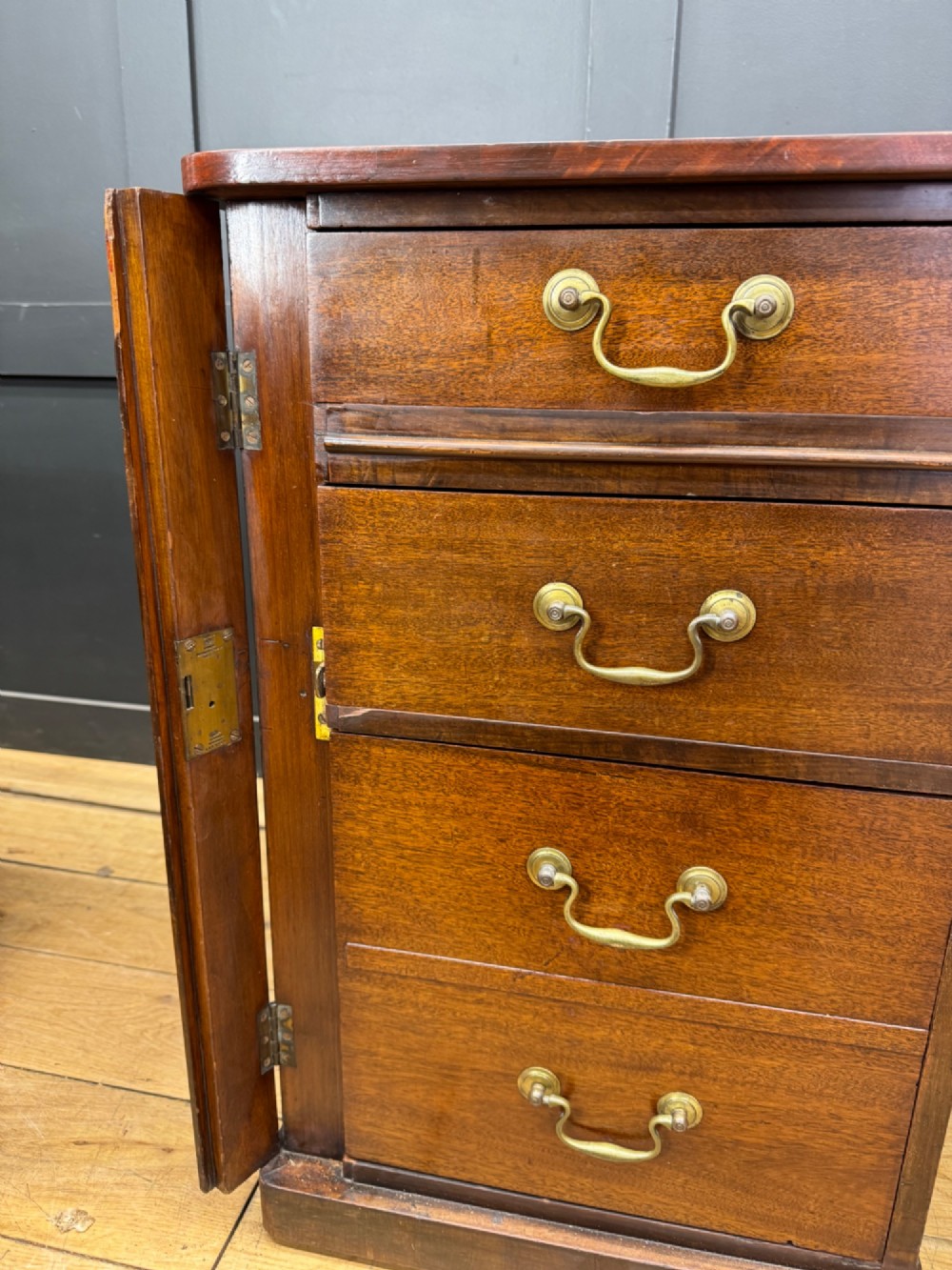 An antique mahogany pedestal desk featuring three frieze drawers, twin drawer pedestals with brass drop handles, and a solid plinth base. View IV