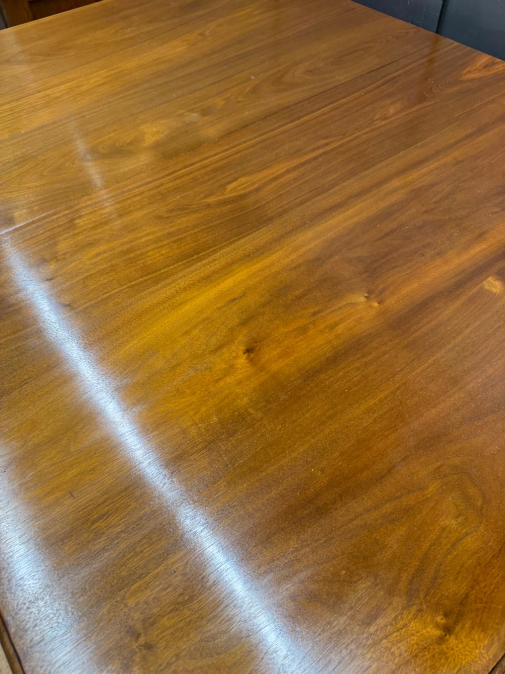 A solid walnut Victorian extending dining table with reeded turned legs set on brass castors. View VI