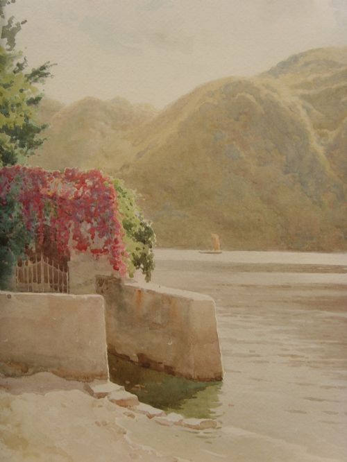 fig 6. A framed Edwardian watercolour painting depicting a sunny Lake Como shore with lush green trees, stone steps, and distant mountains enclosed in an ornate gold gilt frame.