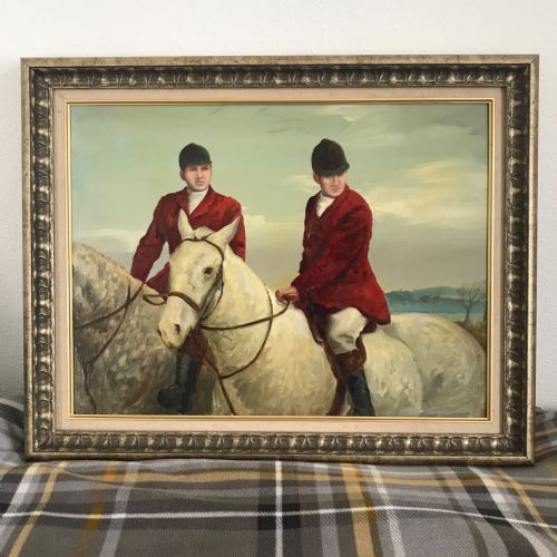 fig 1. An oil painting framed in a silvered carved wood frame depicting two huntsmen wearing red coats mounted on grey horses.