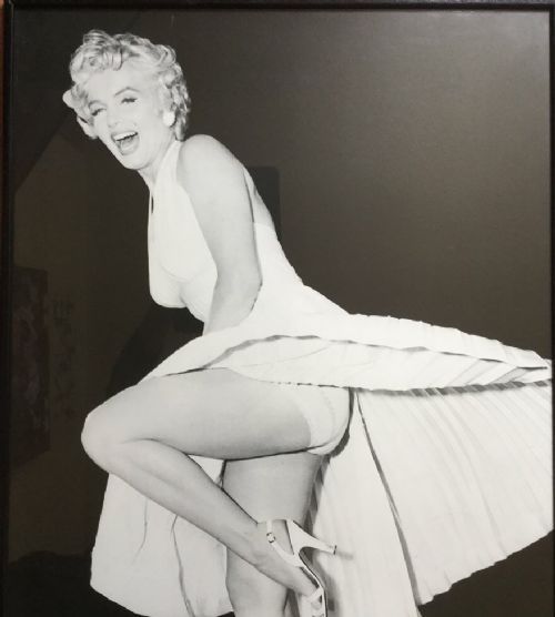 fig 1. A large black-and-white framed photographic print depicting Marilyn Monroe in a full-length portrait pose.