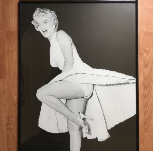 fig 5. A large black-and-white framed photographic print depicting Marilyn Monroe in a full-length portrait pose.