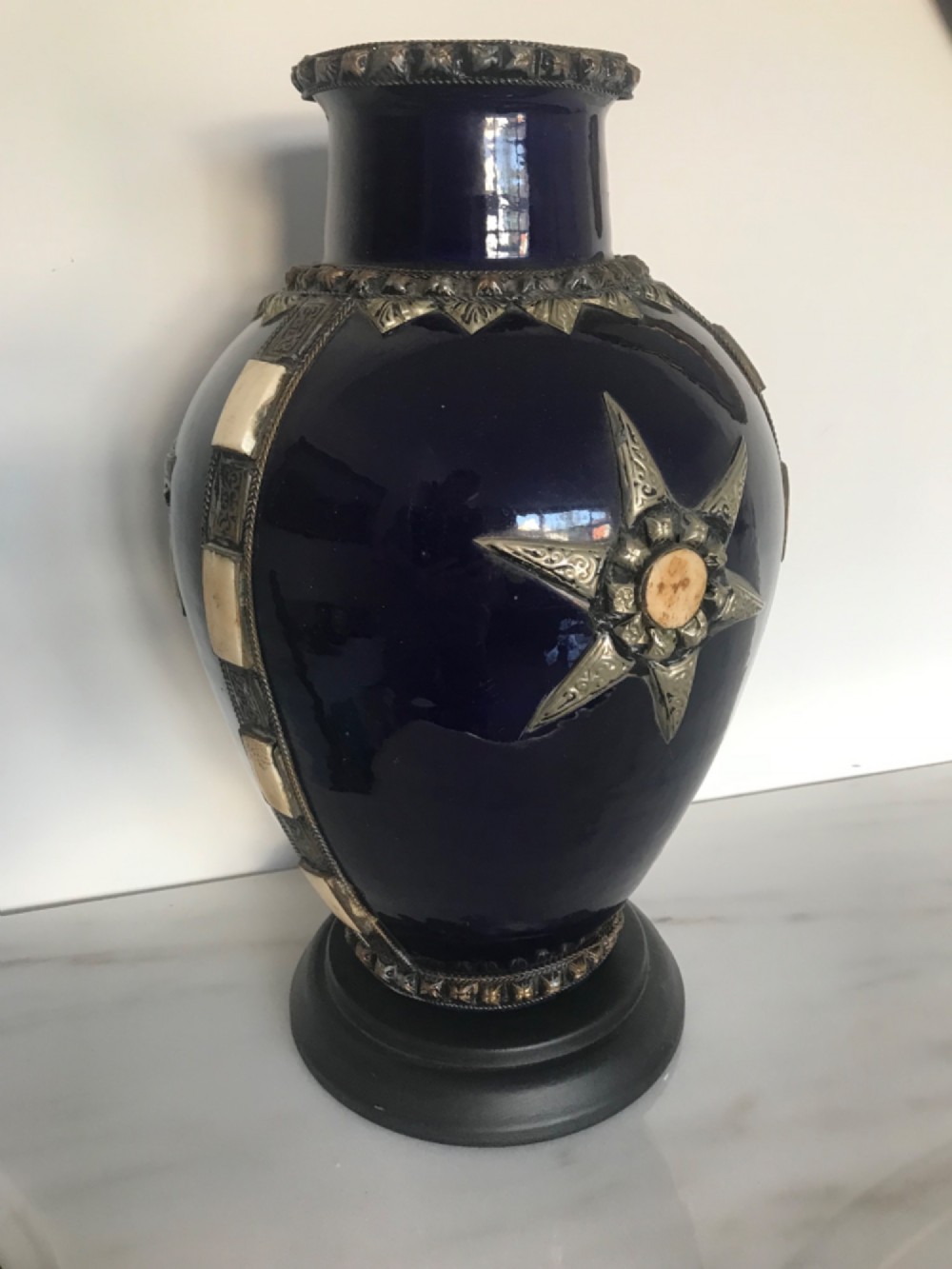 A cobalt blue glazed terracotta vase featuring silver-tone metal mounts, bone inlay strips, a star motif, and a black base.