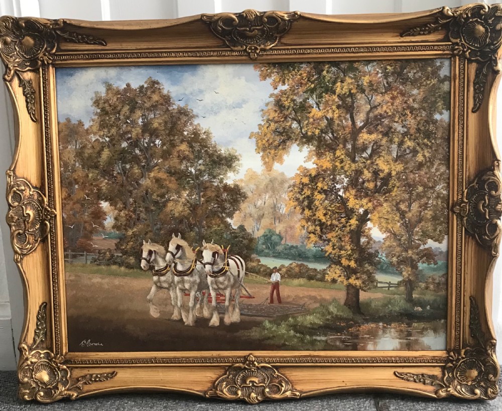 An oil painting depicting three grey shire horses pulling a plough through an autumn field with a farmer, housed in an ornate carved gold frame.