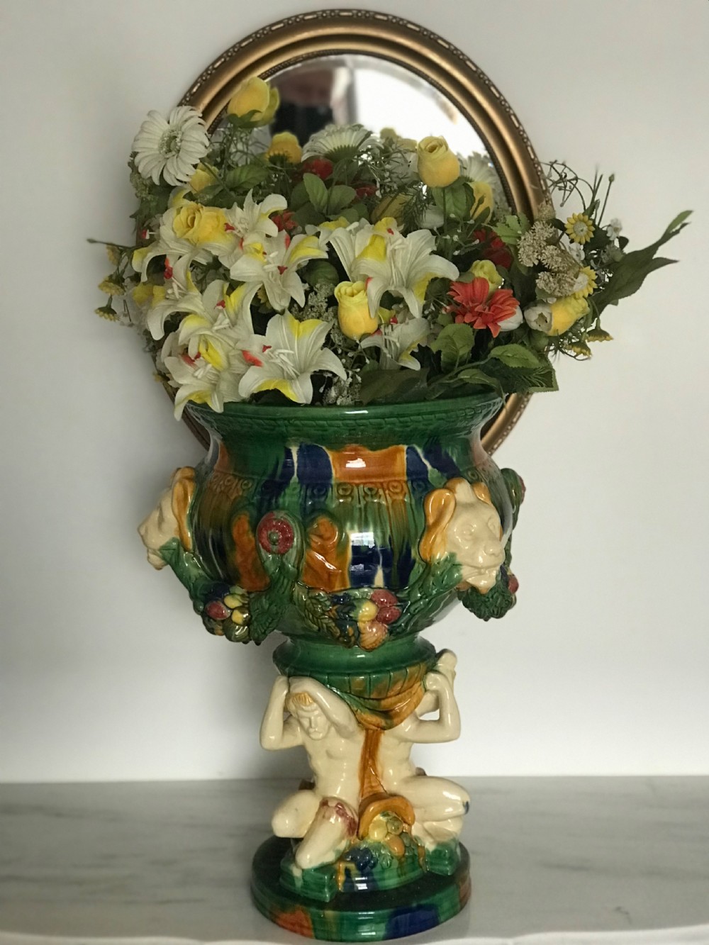 A large Italian majolica ceramic planter decorated with lion head masks and fruit garlands, resting on a sculpted figural base. View XII
