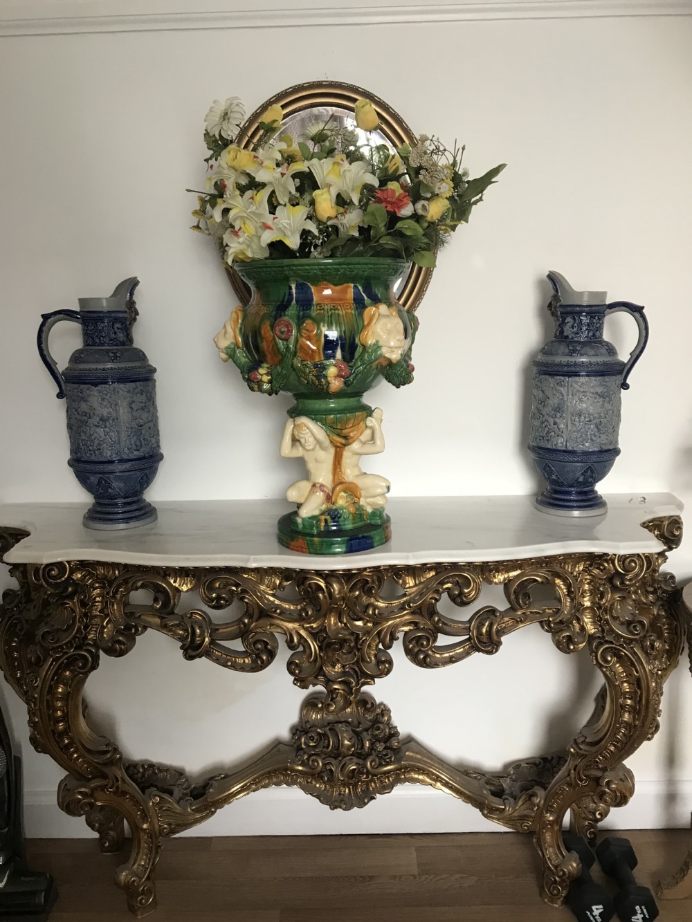 A pair of tall German salt-glazed grey stoneware pitchers featuring cobalt blue accents, mascaron spouts, and relief carvings of Roman battle scenes. View XXIII