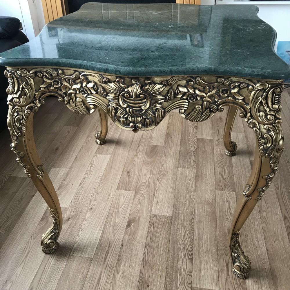 A French Rococo Revival style occasional table with a serpentine green marble top supported by an ornate gilded frame with carved cabriole legs. View VII