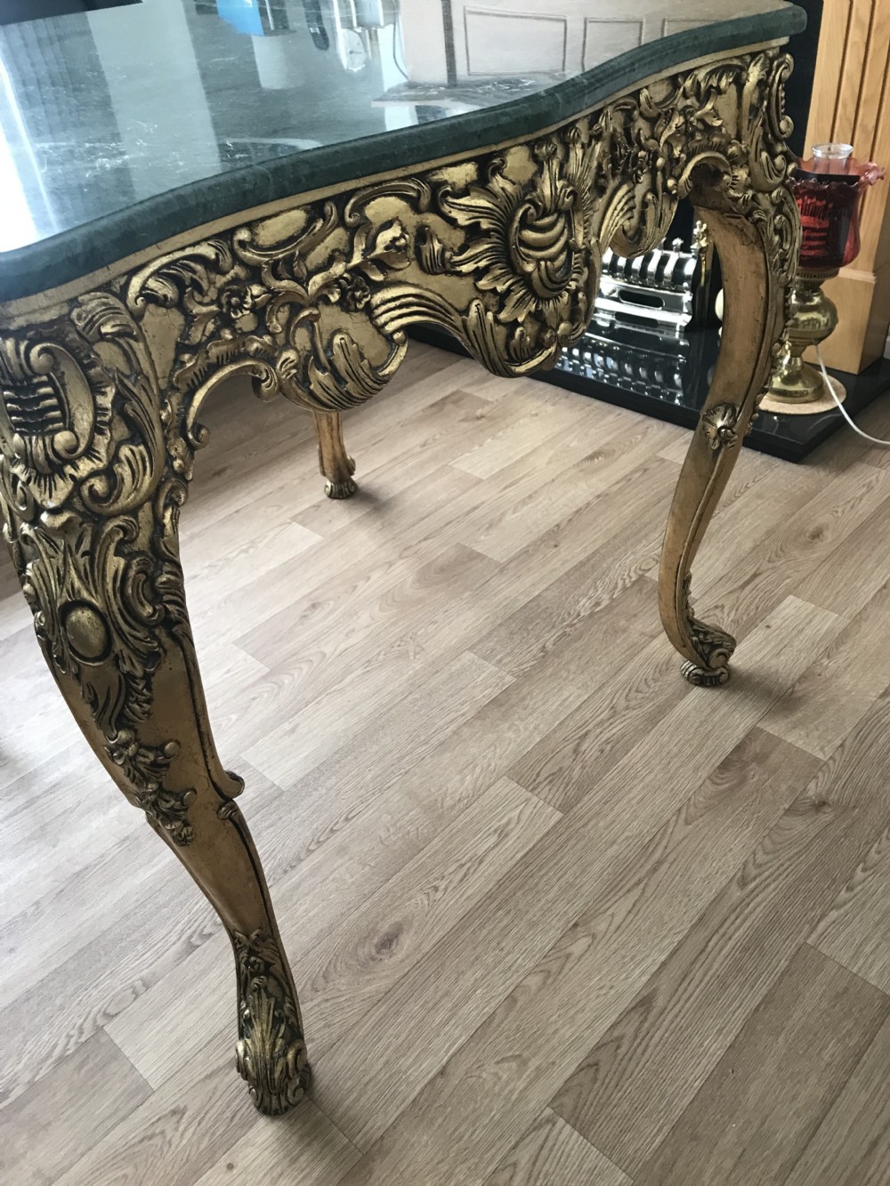 A French Rococo Revival style occasional table with a serpentine green marble top supported by an ornate gilded frame with carved cabriole legs. View XIX