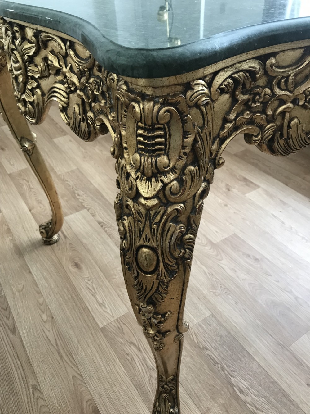 A French Rococo Revival style occasional table with a serpentine green marble top supported by an ornate gilded frame with carved cabriole legs. View XXII