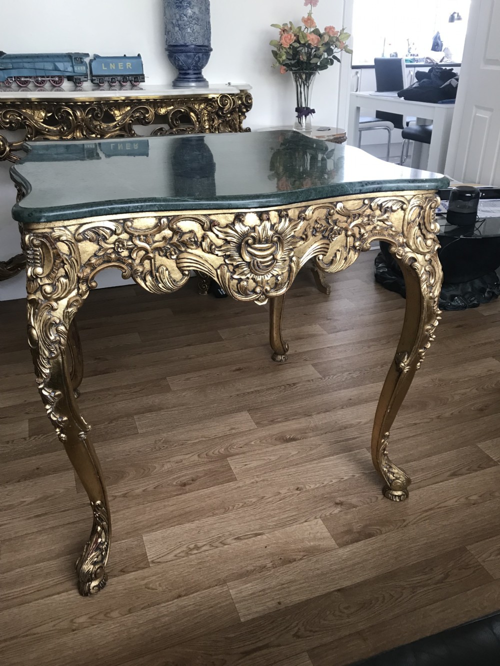 A French Rococo Revival style occasional table with a serpentine green marble top supported by an ornate gilded frame with carved cabriole legs. View VI