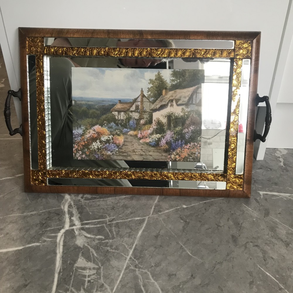 An Art Deco rectangular serving tray featuring a walnut veneer frame, metal side handles, and a mirrored glass surface with a central cottage landscape print framed by gold borders. View II