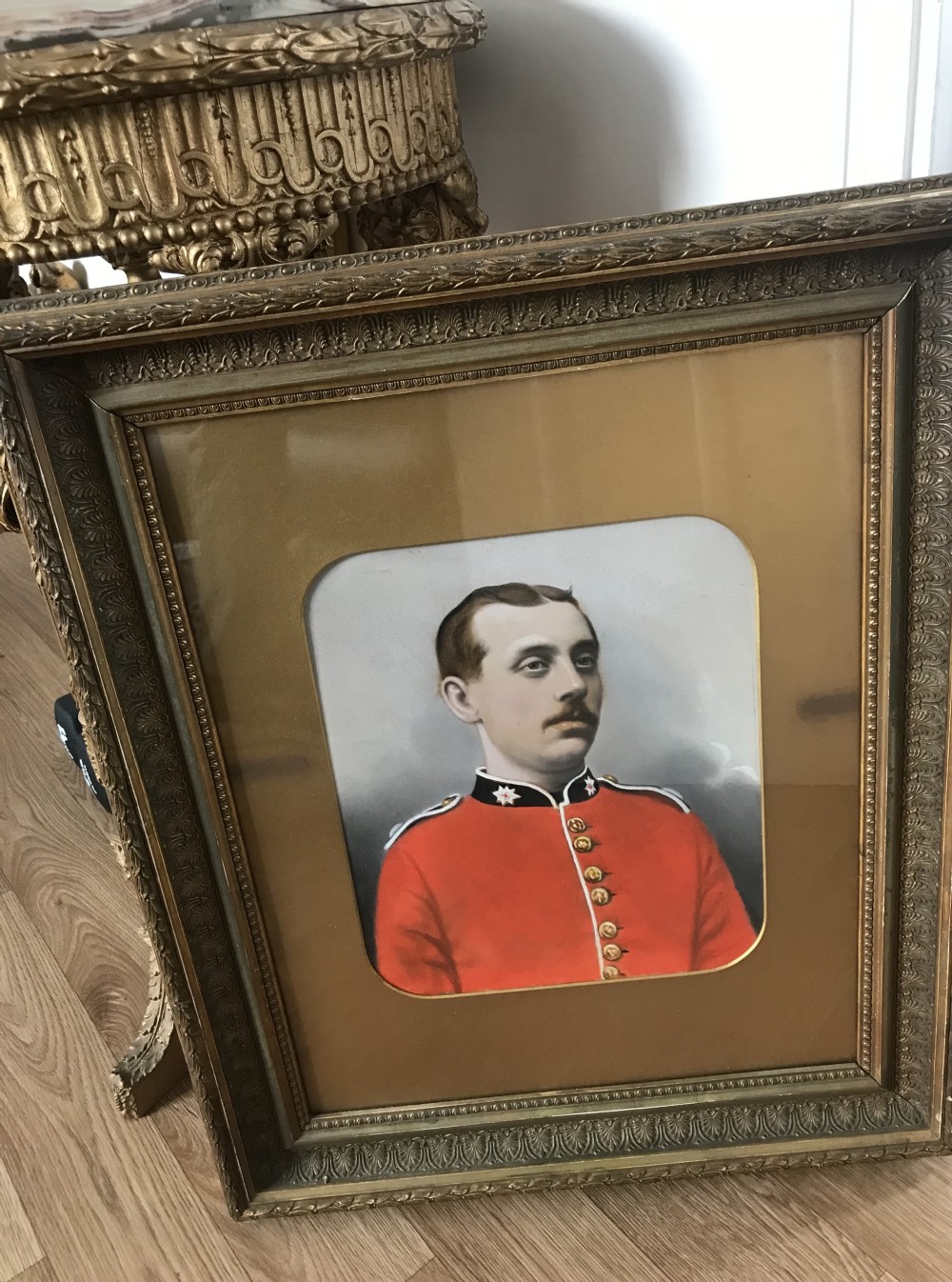 A 19th-century framed oil portrait of a Coldstream Guardsman wearing a scarlet red uniform tunic with gold buttons and a black collar. View VI