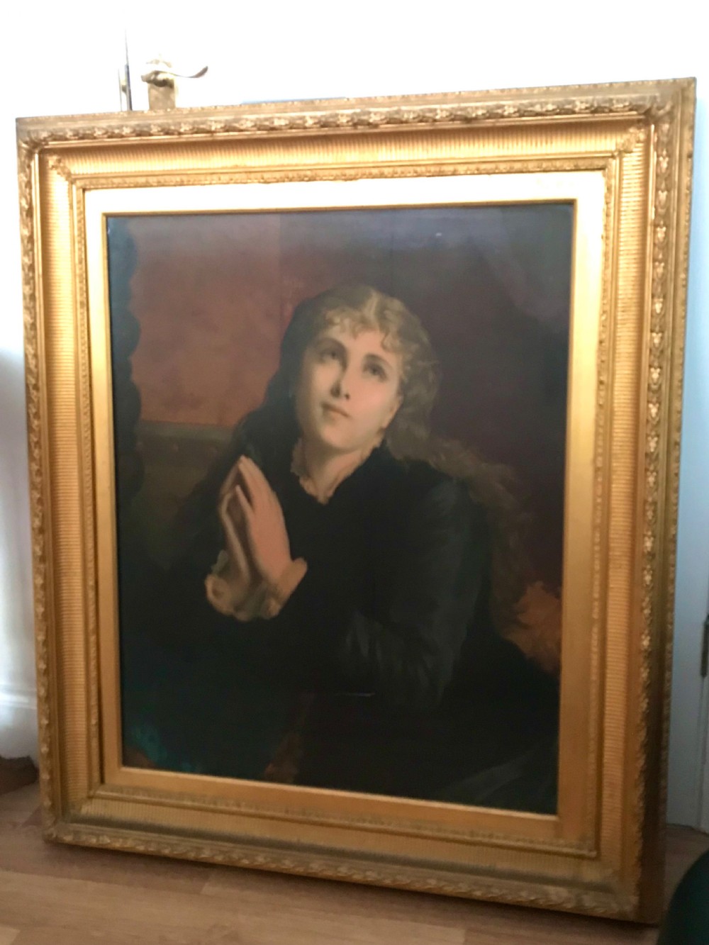 A 19th-century oleograph portrait of Mary Magdalene with clasped hands in prayer, presented inside a deep moulded gold frame under glass.