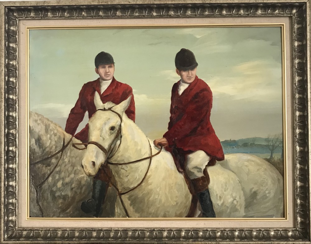 An oil painting framed in silver-toned carved wood depicting two horse riders in red coats mounted on grey horses.