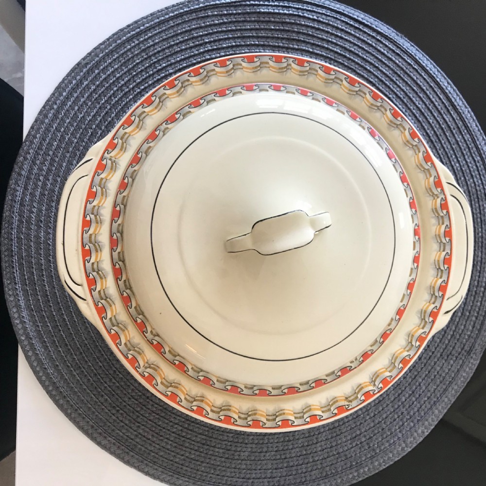 An Art Deco cream earthenware lidded vegetable tureen featuring a geometric pattern in orange and grey along the rim. View III