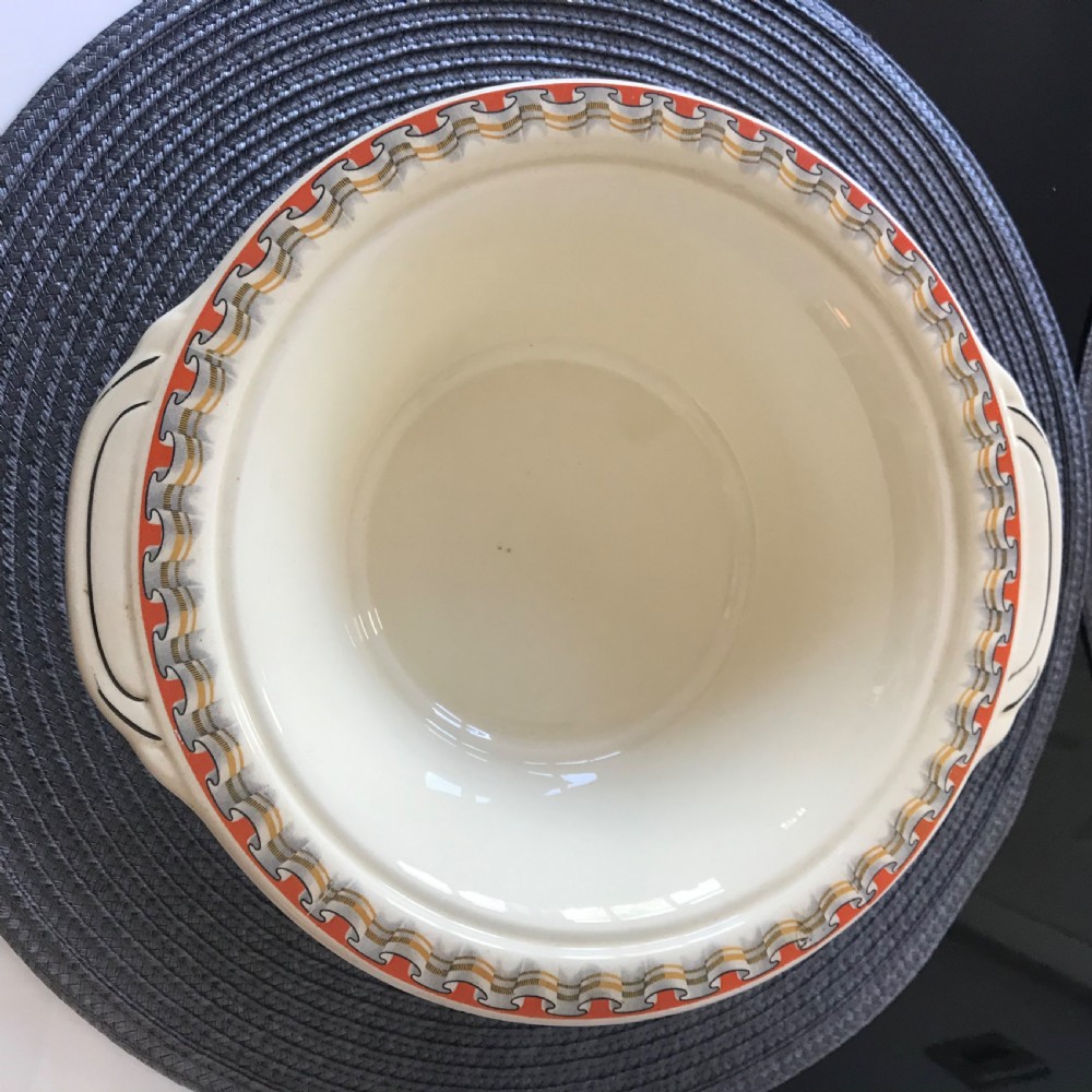 An Art Deco cream earthenware lidded vegetable tureen featuring a geometric pattern in orange and grey along the rim. View IV