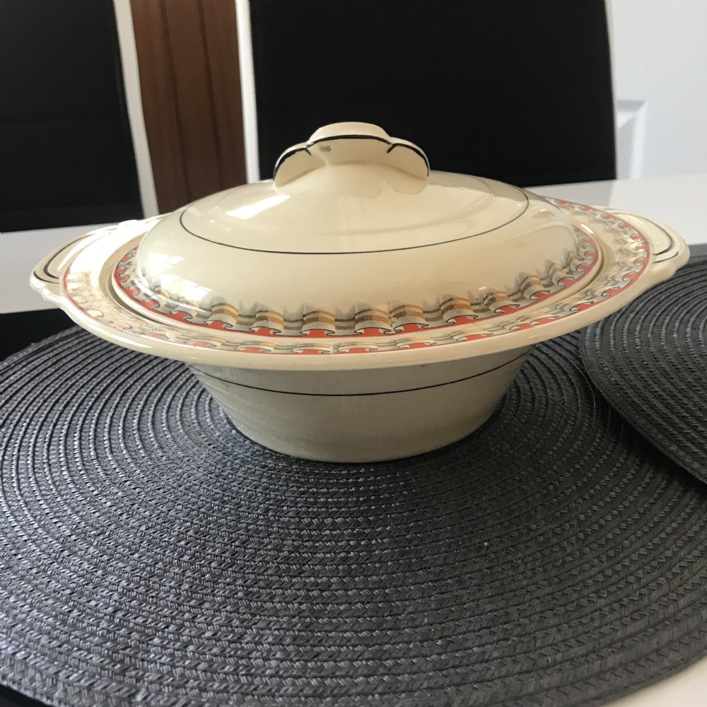 An Art Deco cream earthenware lidded vegetable tureen featuring a geometric pattern in orange and grey along the rim. View XIII
