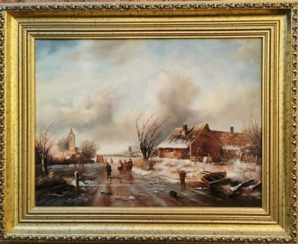 An oil painting depicting a Dutch winter village scene with figures skating on a frozen canal, set within a heavily moulded gilt frame.