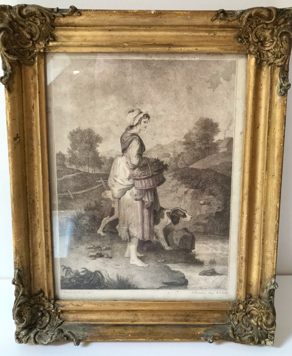 An 18th-century monochrome print depicting a country woman with a basket and dog, set within a heavily carved gold gilt frame.