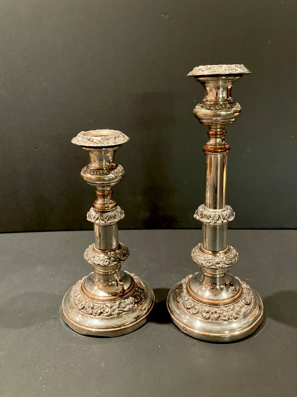 A pair of silver-plated telescopic candlesticks featuring circular embossed bases and adjustable stems. View III