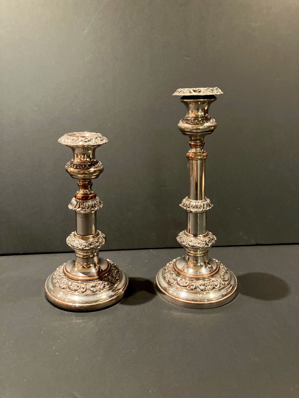 A pair of silver-plated telescopic candlesticks featuring circular embossed bases and adjustable stems. View IV