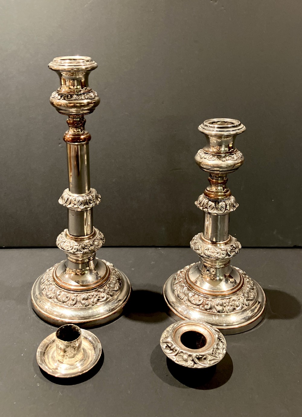 A pair of silver-plated telescopic candlesticks featuring circular embossed bases and adjustable stems. View V