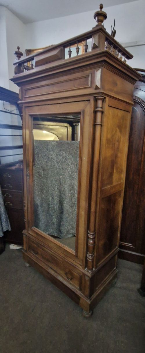 An antique burr walnut single-door armoire with a central bevelled mirror, flanking turned columns, and a lower drawer. View VIII