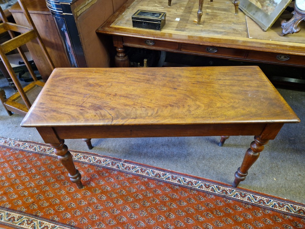 A Victorian mahogany hall side table featuring a plain rectangular top, a solid apron, and four turned baluster legs. View VII