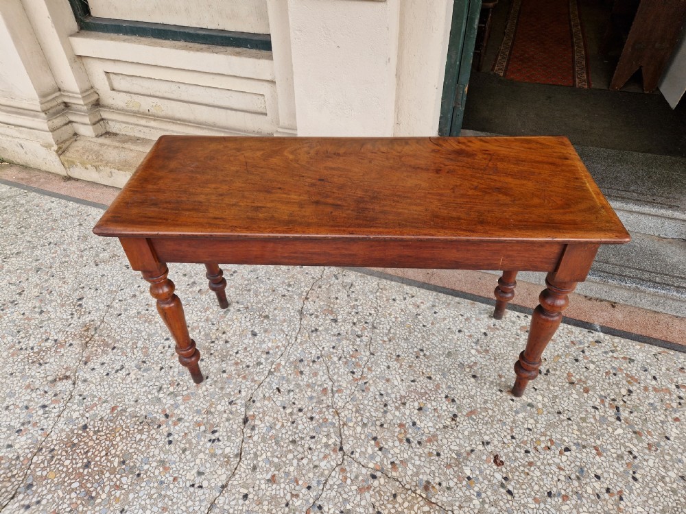 A Victorian mahogany hall side table featuring a plain rectangular top, a solid apron, and four turned baluster legs. View VIII