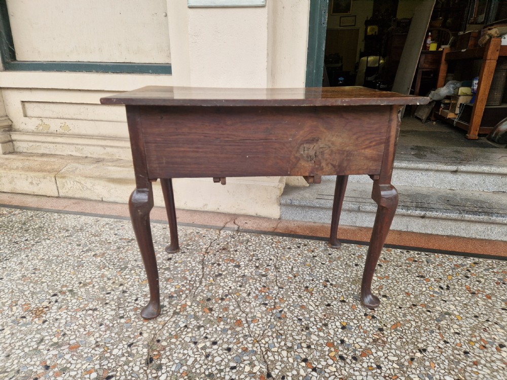 An antique oak lowboy featuring three drawers with brass drop handles, a scalloped apron, and four cabriole legs resting on pad feet. View XI