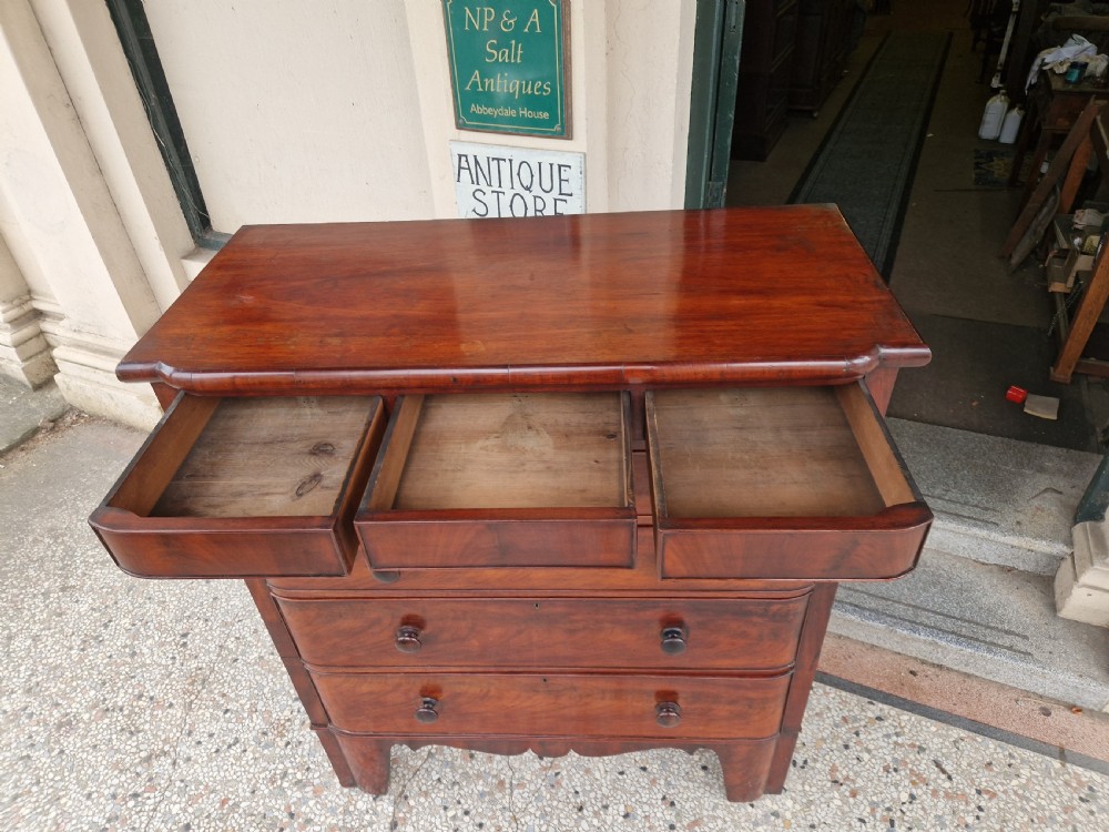 A Victorian mahogany chest of drawers featuring a top frieze drawer above two short and three long graduated drawers with turned knobs. View III
