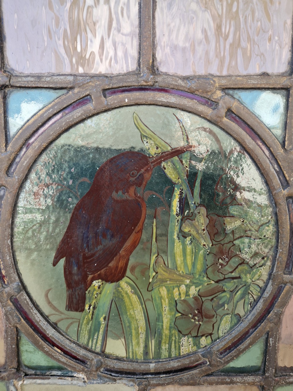 A rectangular Victorian leaded glass panel set in a timber frame, featuring pastel geometric panes, four decorative corner inserts, and a central roundel depicting a hand-painted bird. View IV