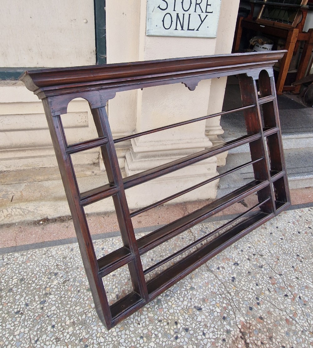 A dark-stained antique oak delft wall rack featuring open shelves, side compartments, and a heavy moulded cornice. View III