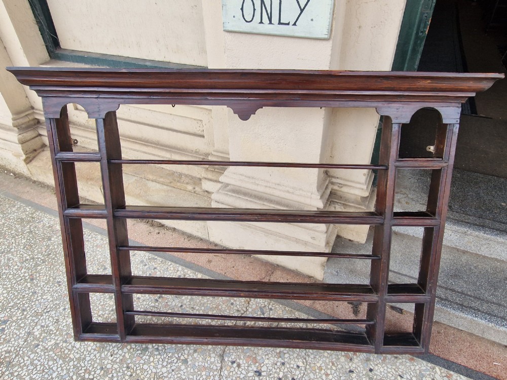 A dark-stained antique oak delft wall rack featuring open shelves, side compartments, and a heavy moulded cornice. View IV