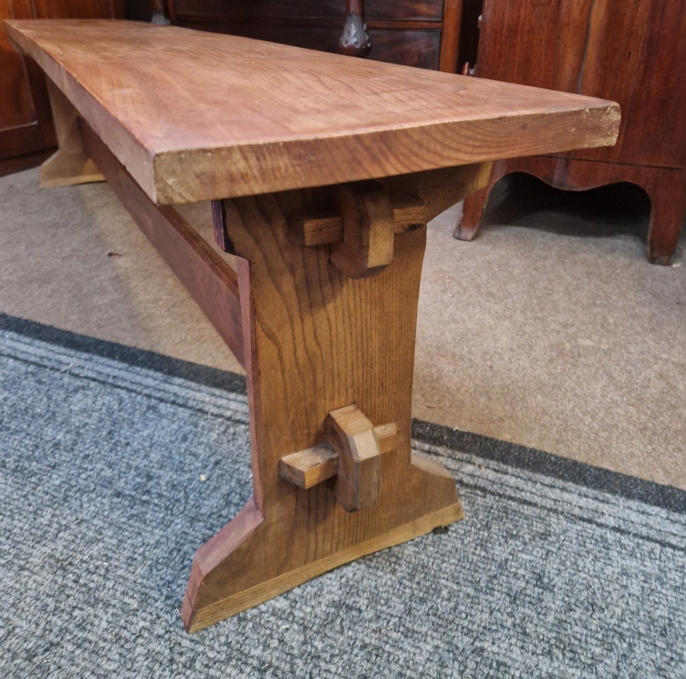 A pair of long solid oak benches featuring flat plank tops, trestle legs, and horizontal wooden stretchers. View IV