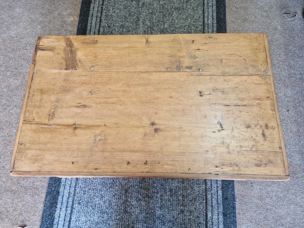 A rectangular antique pine storage box with a hinged lid, tapered sides, a moulded base, and an iron keyhole escutcheon on the front. View V