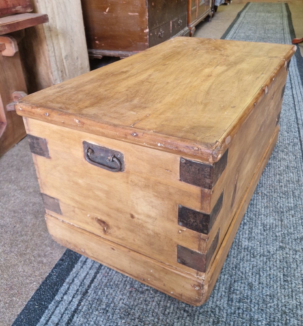 An antique pine blanket box featuring iron corner straps, a brass keyhole escutcheon, and a hinged lid. View II