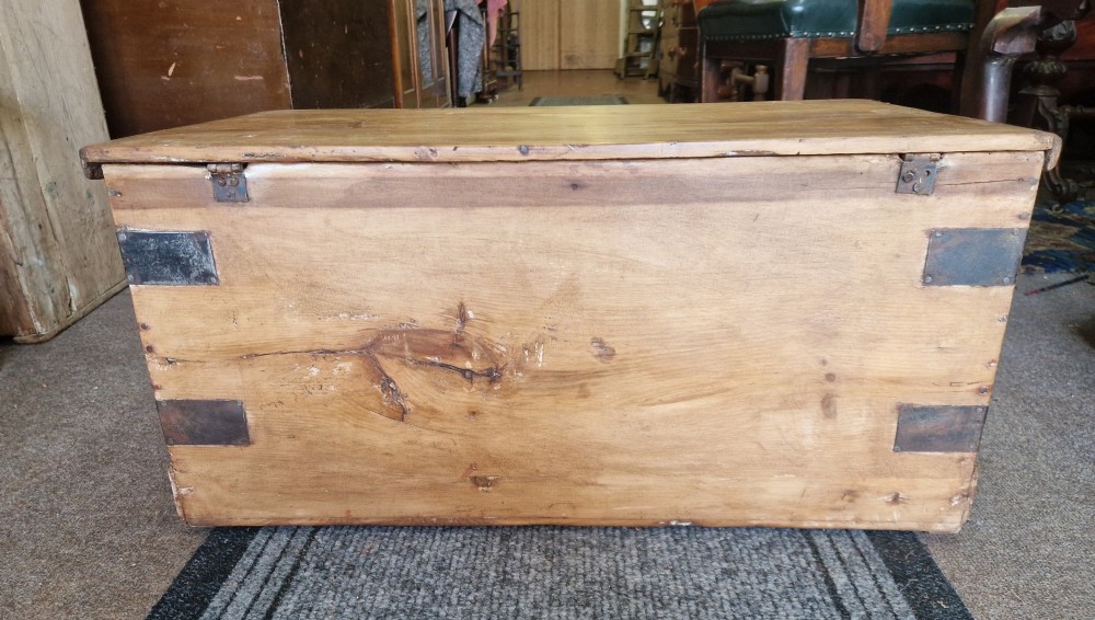 An antique pine blanket box featuring iron corner straps, a brass keyhole escutcheon, and a hinged lid. View IV