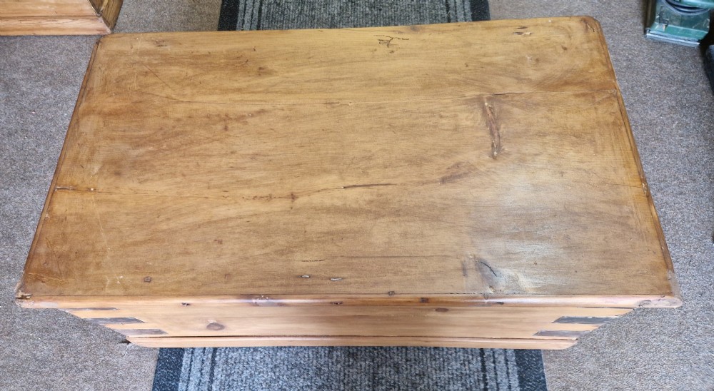 An antique pine blanket box featuring iron corner straps, a brass keyhole escutcheon, and a hinged lid. View VI
