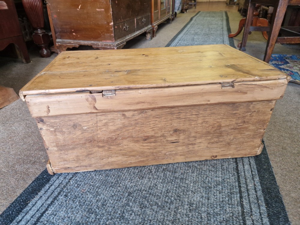 An antique pine blanket box featuring iron corner straps, a brass keyhole escutcheon, and a hinged lid. View VII
