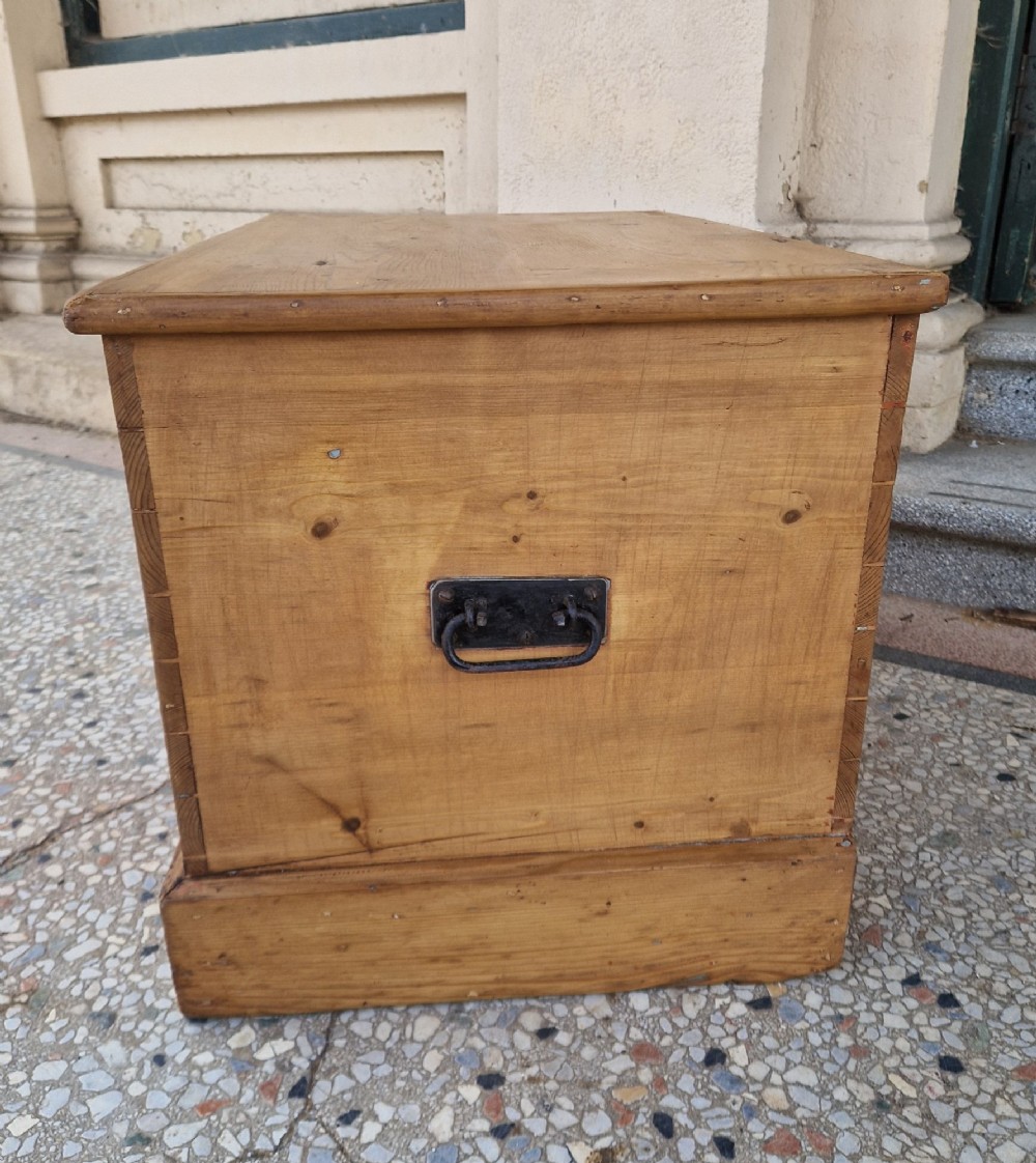 A rectangular Victorian pine blanket box featuring a hinged top lid, visible dovetail joints at the corners, and a solid plinth base. View VII
