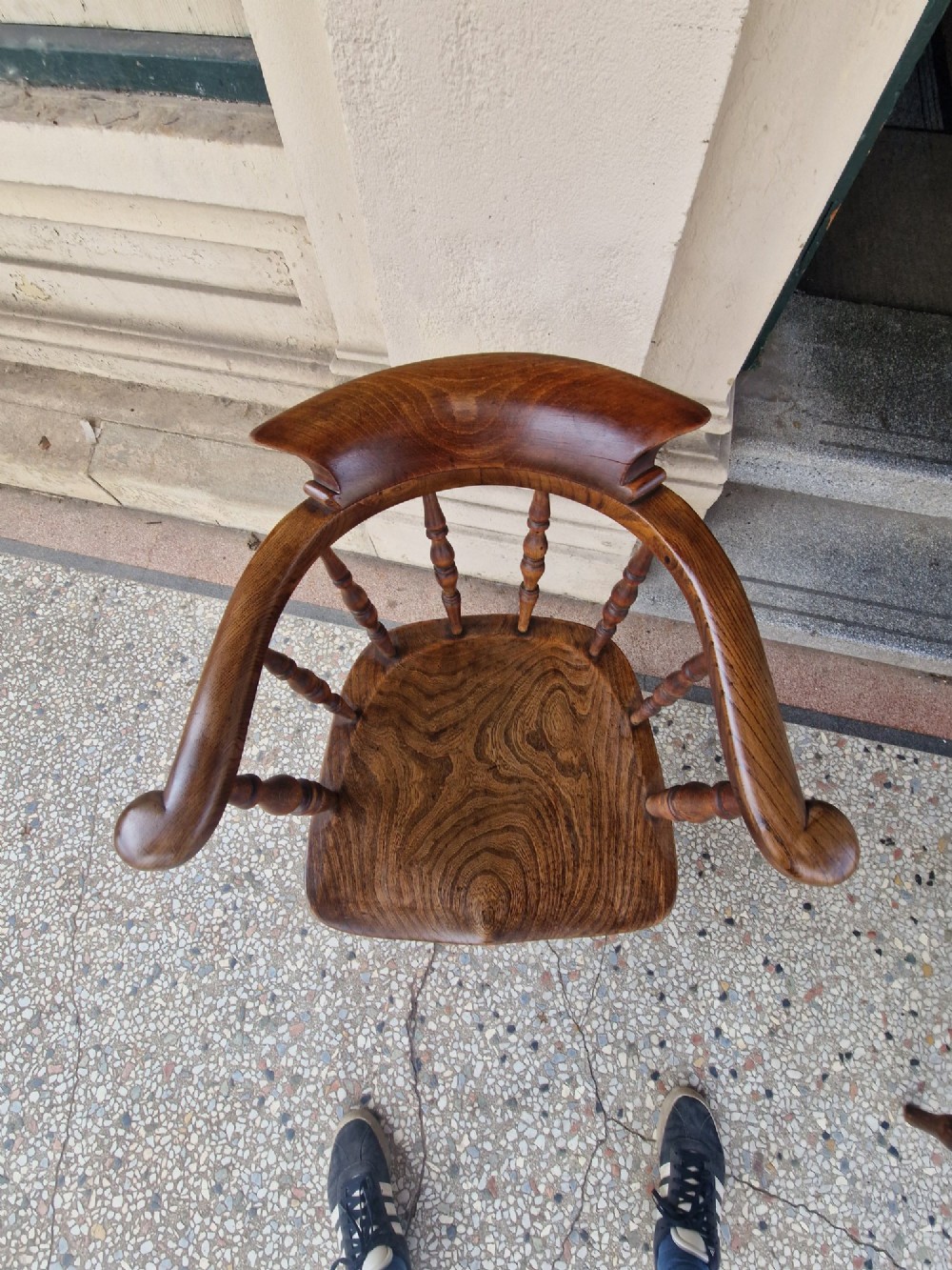 A pair of antique warm brown ash and elm captains armchairs featuring curved horseshoe backrests, turned spindles, shaped saddle seats, and turned legs. View VI
